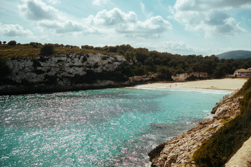 Image moored yachts on bright blue bay Cala Blanca Andratx, Palma de Mallorca, rocky coast breathtaking view, Balearic Islands Spain.