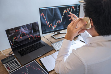 Fototapeta premium Stock exchange market concept, Business investor trading or stock brokers having a planning and analyzing with display screen and pointing on the data presented and deal on a stock exchange