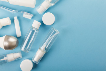 Travel small bottle set on blue background. Top view, copy space