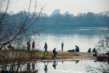 People on the banks of the river in spring relax.
