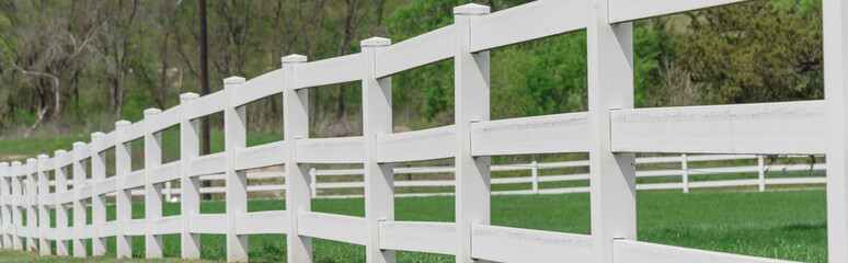 Fototapeta premium Panoramic long wooden white fence to horizontal line in cloud blue sky at farmland in Ennis, Texas, USA