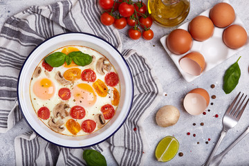 Backed eggs with tomatoes, mushrooms and spices. Healthy homemade breakfast. 