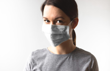 Coronavirus concept. Girl wearing a protective medical mask. Protect your health. Stop the virus and pandemic covid-19. Light gray background