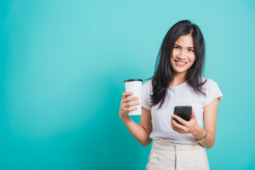 woman standing smile, using mobile phone her holding coffee paper cup