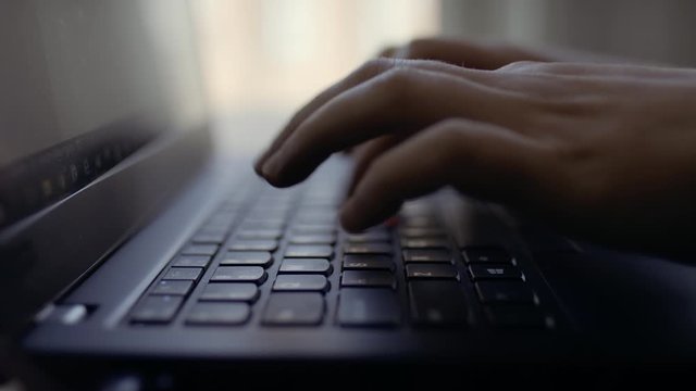 Fingers type on laptop keyboard. Profile of fingers. Closeup shot in 4k