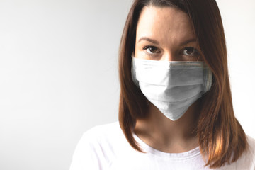 Coronavirus concept. Girl wearing a protective medical mask. Protect your health. Stop the virus and pandemic covid-19. Light gray background