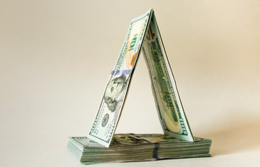 American 100 dollar bills are folded in the form of a house of cards. Savings, planning, forecasts.