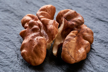 kernel walnut lies on a black rough surface. macro photo. peeled nut
