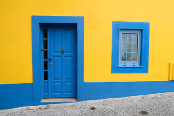 Bright blue and yellow house with a wooden door