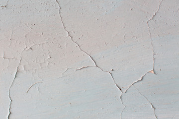 Wall with cracked white paint. Texture of old peeling paint, vintage background, cracked paint, old paint, traces of beige paint.