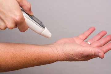 Person measuring temperature with thermometer in wrist