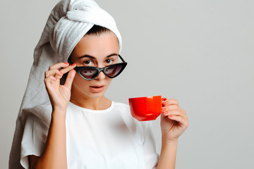 Portrait of a beautiful surprised young woman wearing a towel and looking from behind her...