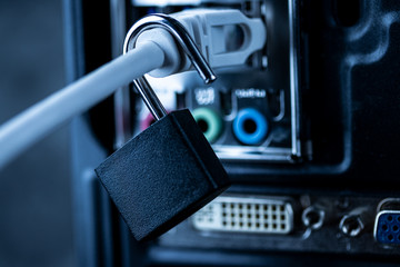 Opened lock hanging on a network cable plugged into a computer. The concept of opening access,...