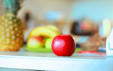  Red apple and diverse fruits on a table in a modern kitchen. Useful Conception of proper nutrition