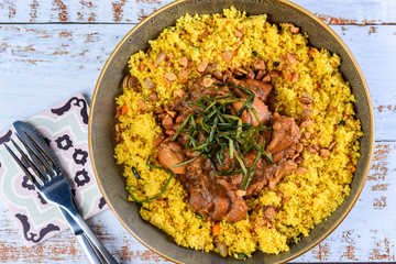 A traditional Moroccan dish called Chicken Tajine featuring Saffron, Honey, Almonds, Dates, Couscous and Labneh