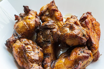 Delicious portion of grilled chicken legs served in a white plate