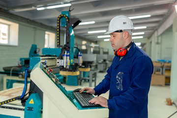Naklejka premium Worker in the Hard Hat Modern Factory CNC machine operator . Successful, Handsome Man in Modern Industrial Environment.Emotions, Copy Space