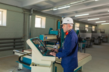 Worker in the Hard Hat Modern Factory CNC machine operator . Successful, Handsome Man in Modern Industrial Environment.Emotions, Copy Space