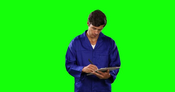 Front view of mechanic taking note with green screen