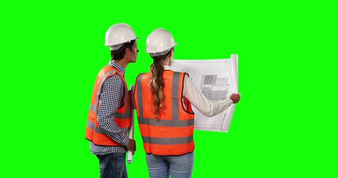 Rear view of site workers looking at the site map with green screen