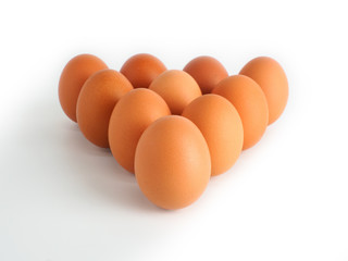 Chicken eggs laying triangle on white background