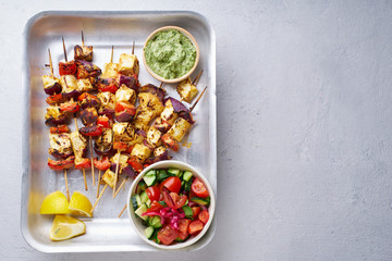 Paneer tikka starter kebabs with mint chutney and chapati. Traditional indian cuisine, grilled cheese skewers with onion and bell pepper slices. Vegetarian dish marinated in tikka sauce.