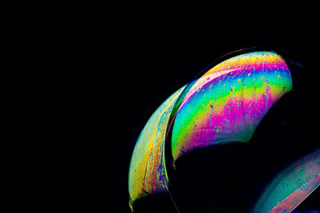 Selective focus on abstract colored soap sphere on a black background