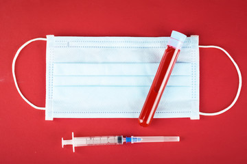 Medical mask and a test tube with a blood test on table. Coronavirus Pandemic. Horizontal.