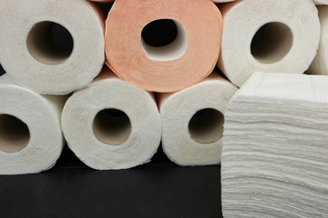 Rolls of white toilet paper on a black background