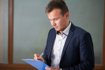 Solid businessman in a jacket works with documents in the office of the company