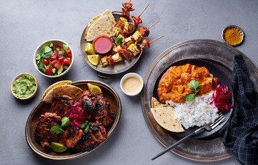 Indian food tandoori chicken, paneer tikka kebab, mint chutney and paneer tikka masala with basmati rice. Top view with assorted indian cuisine meal.