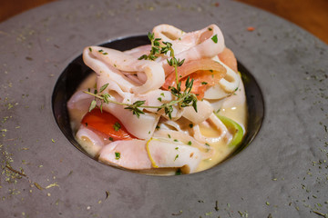 Plate with squid in white wine. Tasty food. Tasty seafood.