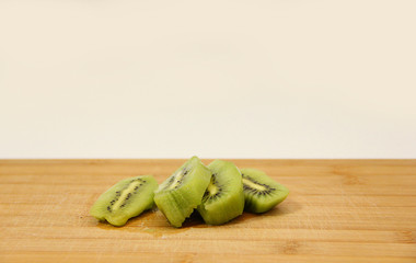 green kiwi cut on a chopping Board
