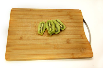 green kiwi cut on a chopping Board