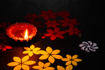 one glowing terracotta lamp on dark black background. Luxmi pooja concept