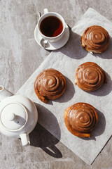 Cinnamon rolls and cream. Tea party. Still life. Vertical photo.