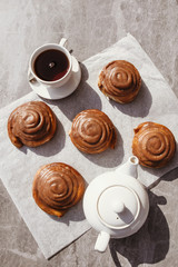 Cinnamon rolls and cream. Tea party. Still life. Vertical photo.
