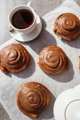 Cinnamon rolls and cream. Tea party. Still life. Vertical photo.