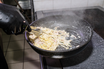 The process of making carbonara pasta for restaurant guests. Tasty food.