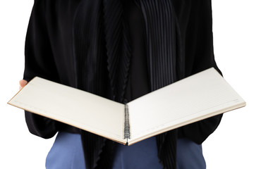 Isolated with clipping path. Asian woman muslim student holding a notebook close up. Graduate muslim student open a notebook close up with copy space. Learning and knowledge concept.