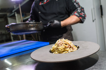 The process of making carbonara pasta for restaurant guests. Tasty food.