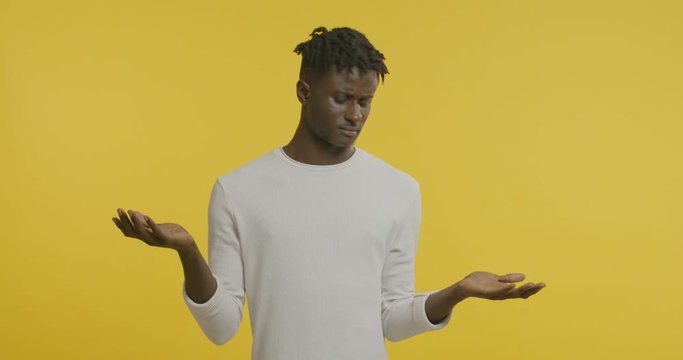 Doubtful african guy choosing between right and left hands