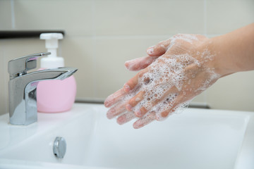 Woman washing her hands by using liquid hand washer soap for protecting from coronavirus 2019, COVID-19 virus inflection risk. Washing a hands can increase personal hygiene and protect from virus.