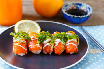 Sushi salmon on a plate and orange juice put on the table