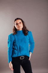 portrait of a beautiful young fashionable woman in a blue sweater