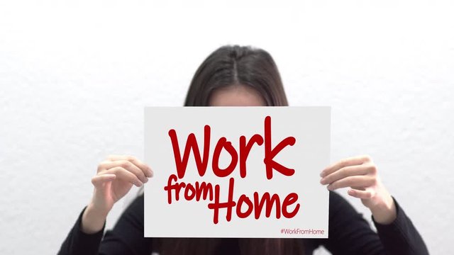 Hispanic female holding sheet of paper with text work from home for protect from corona virus and take care of their health from COVID-19. Working at home concept