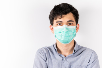 young Asian man wearing green sanitation mask on face on white background in studio and looking at the camera. COVID-19 concept. health care and safety.