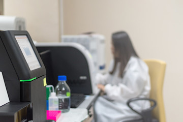 DNA sequencing in science room with blur background of female scientist working in university research laboratory or hospital. Blurry view of lab technologist test specimen in science room.