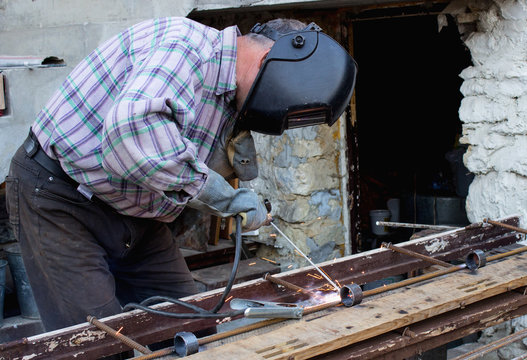 Work in the industry. A man works with a welding machine