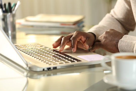 Black man hands using touchpad on laptop at home
